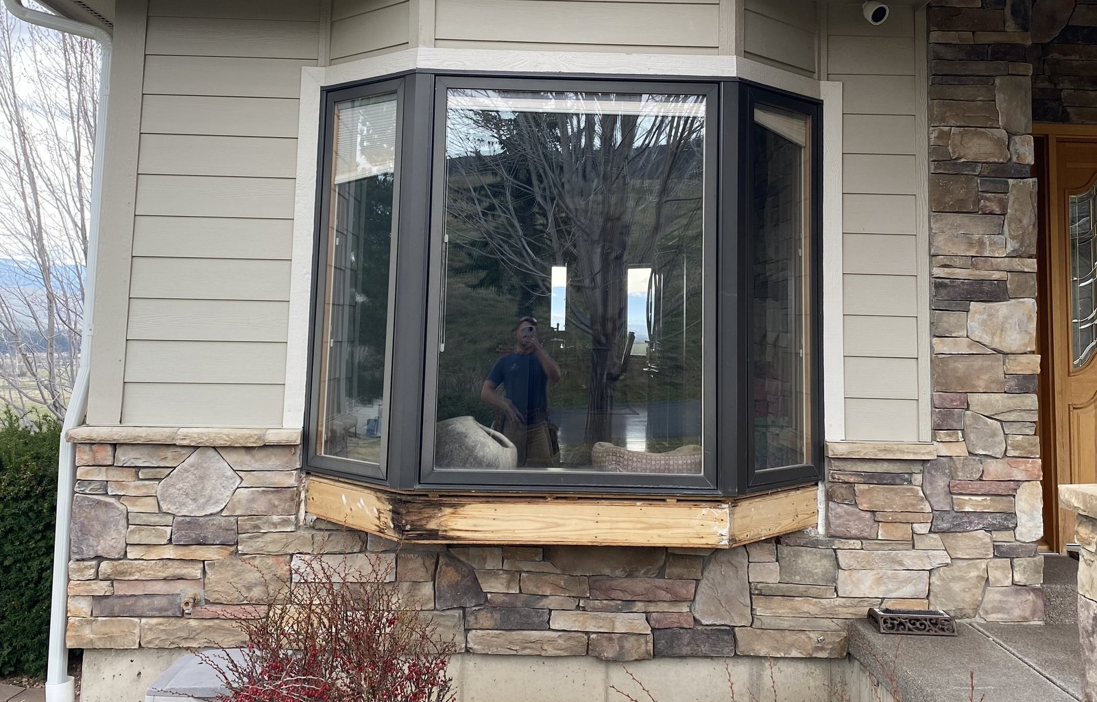 Before photo of damaged bay window trim and base